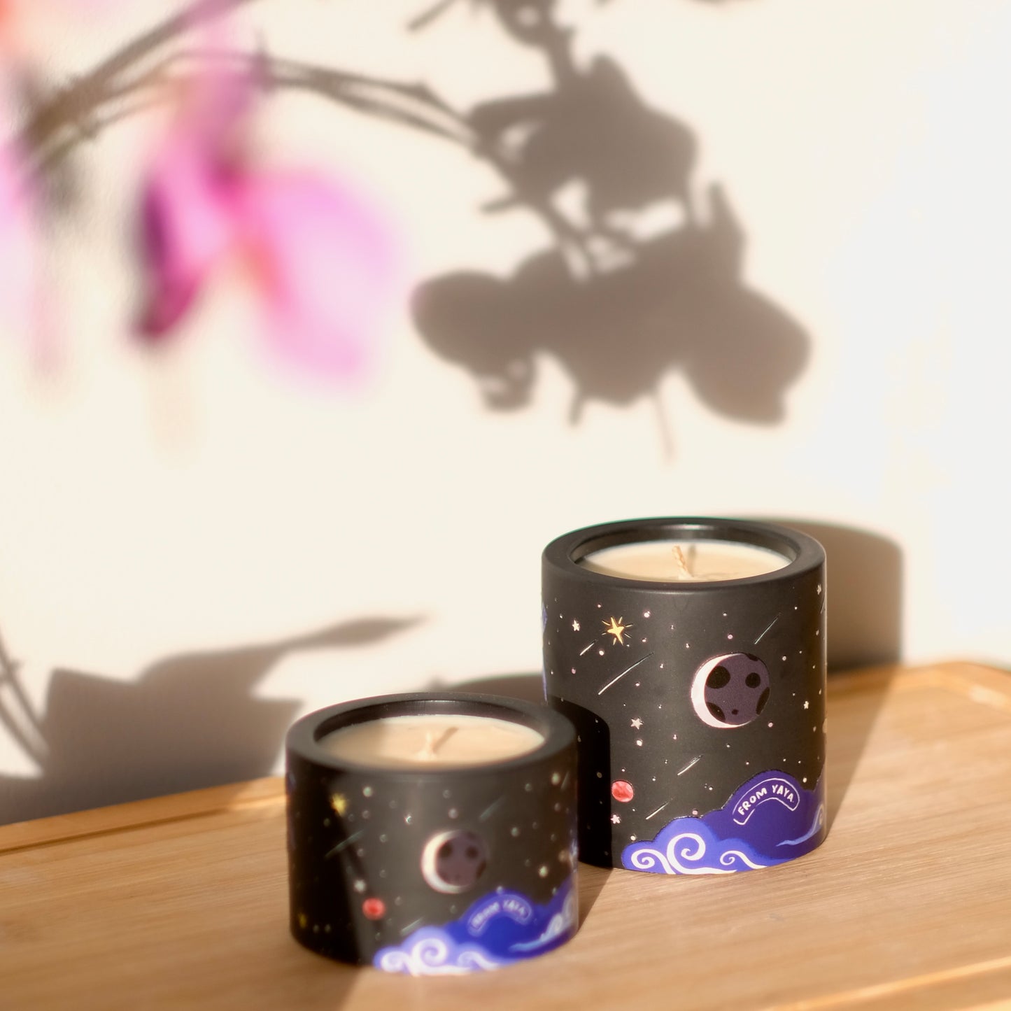 Small and large Midnight natural essential oil candle side by side, with illustrated night sky vessel
