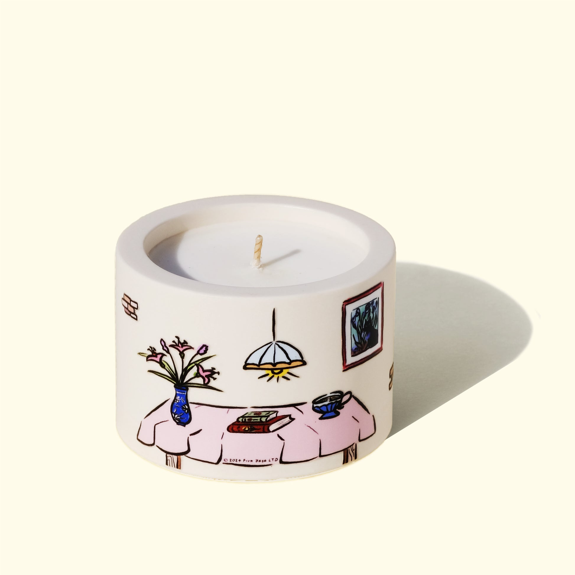 Backside of joyful essential oil candle. Illustratoin of a table with books, flowers and a cup of tea.